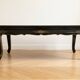 Antique Chinese coffee table in black and gold lacquered wood.