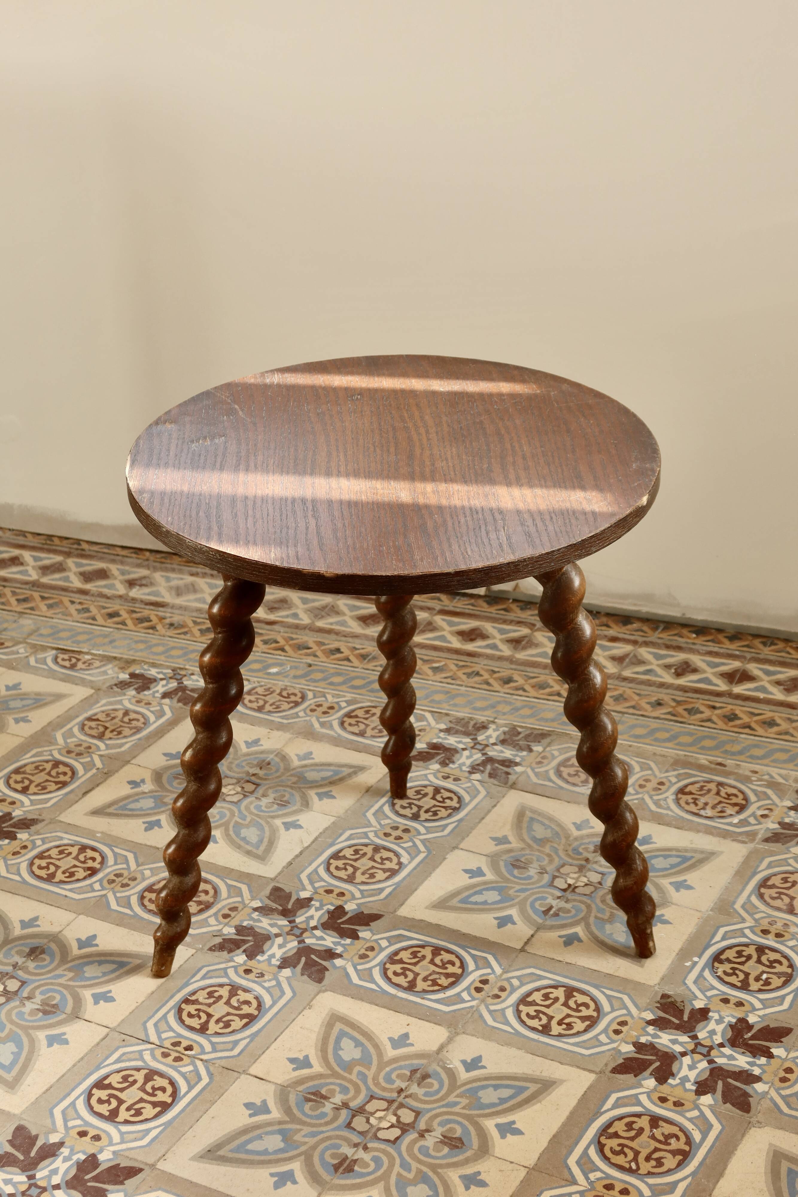 Vintage circular side table in wood with turned legs.