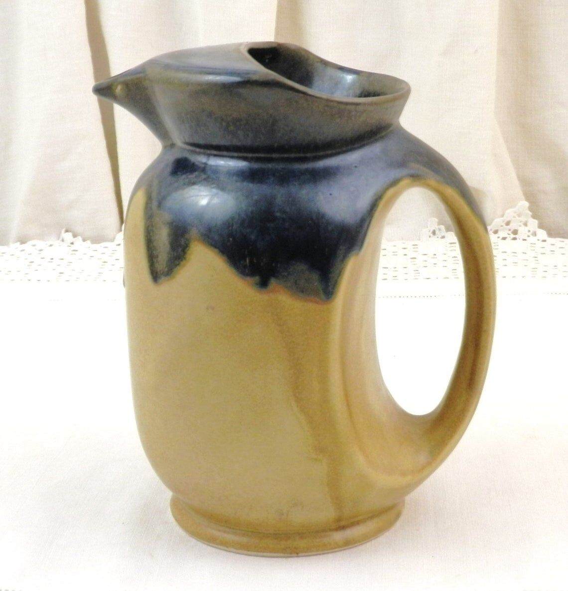 Vintage art deco water pitcher with drippy dark blue glaze.