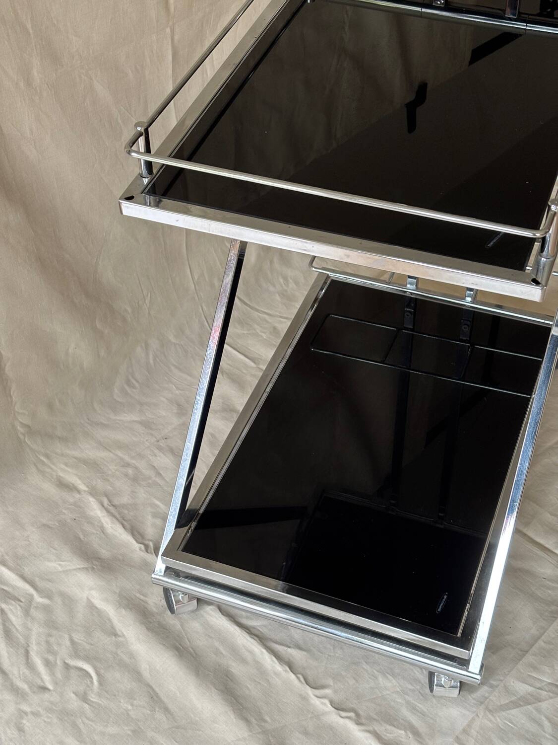 Modernist serving trolley in chromed metal and black smoked glass