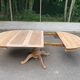 Round dining table with a central pedestal, extendable, stripped in solid walnut with 2 extensions.