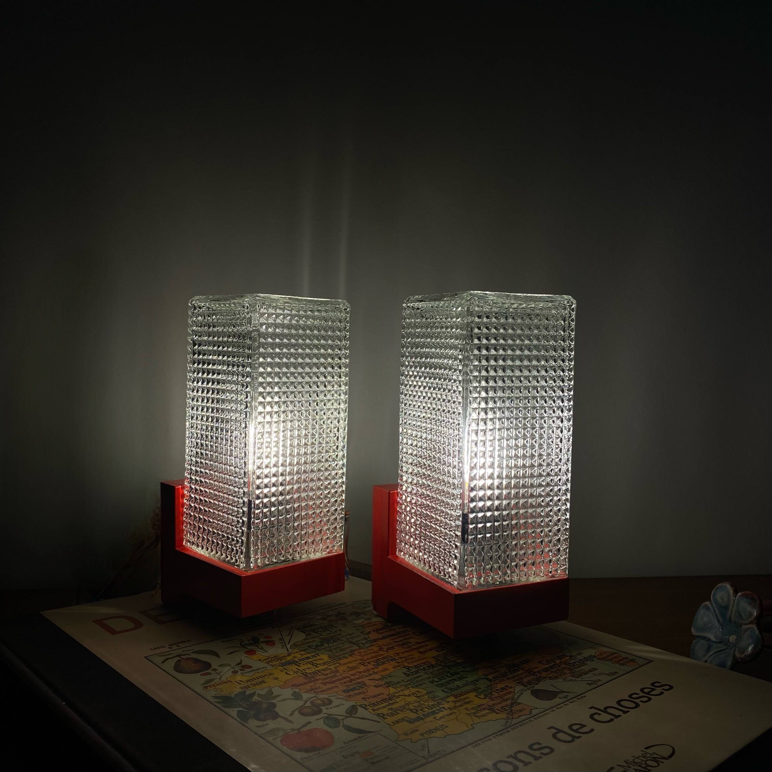 Pair of vintage wall lights in red plastic and clear glass.