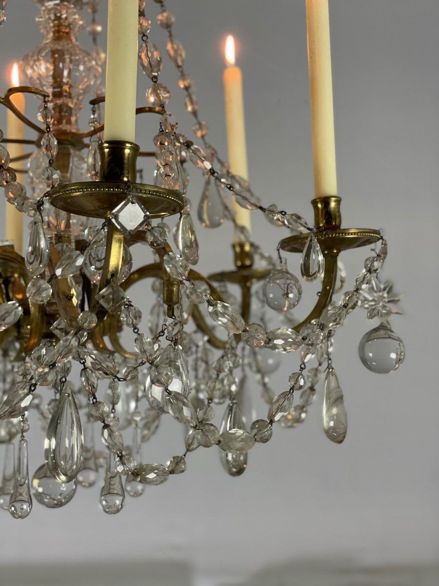 Golden bronze chandelier trimmed with drop-shaped grapevines