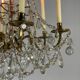 Golden bronze chandelier trimmed with drop-shaped grapevines