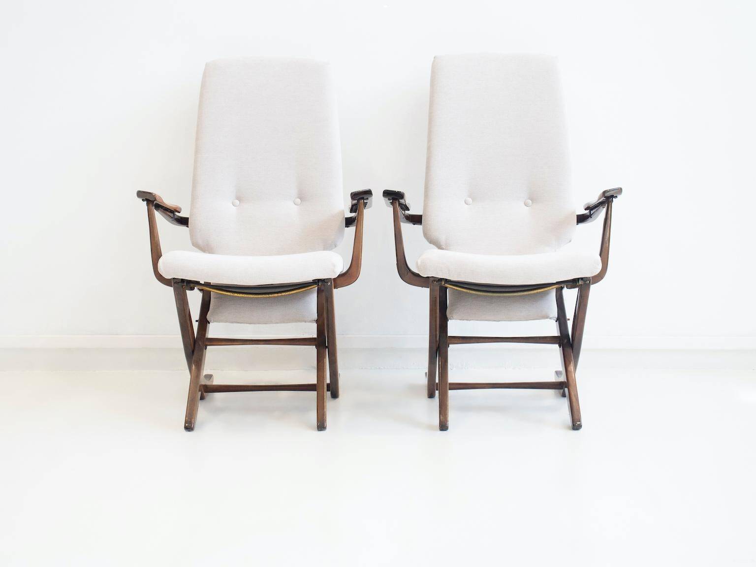 Pair of varnished wooden reclining armchairs, upholstered in lightweight fabric.