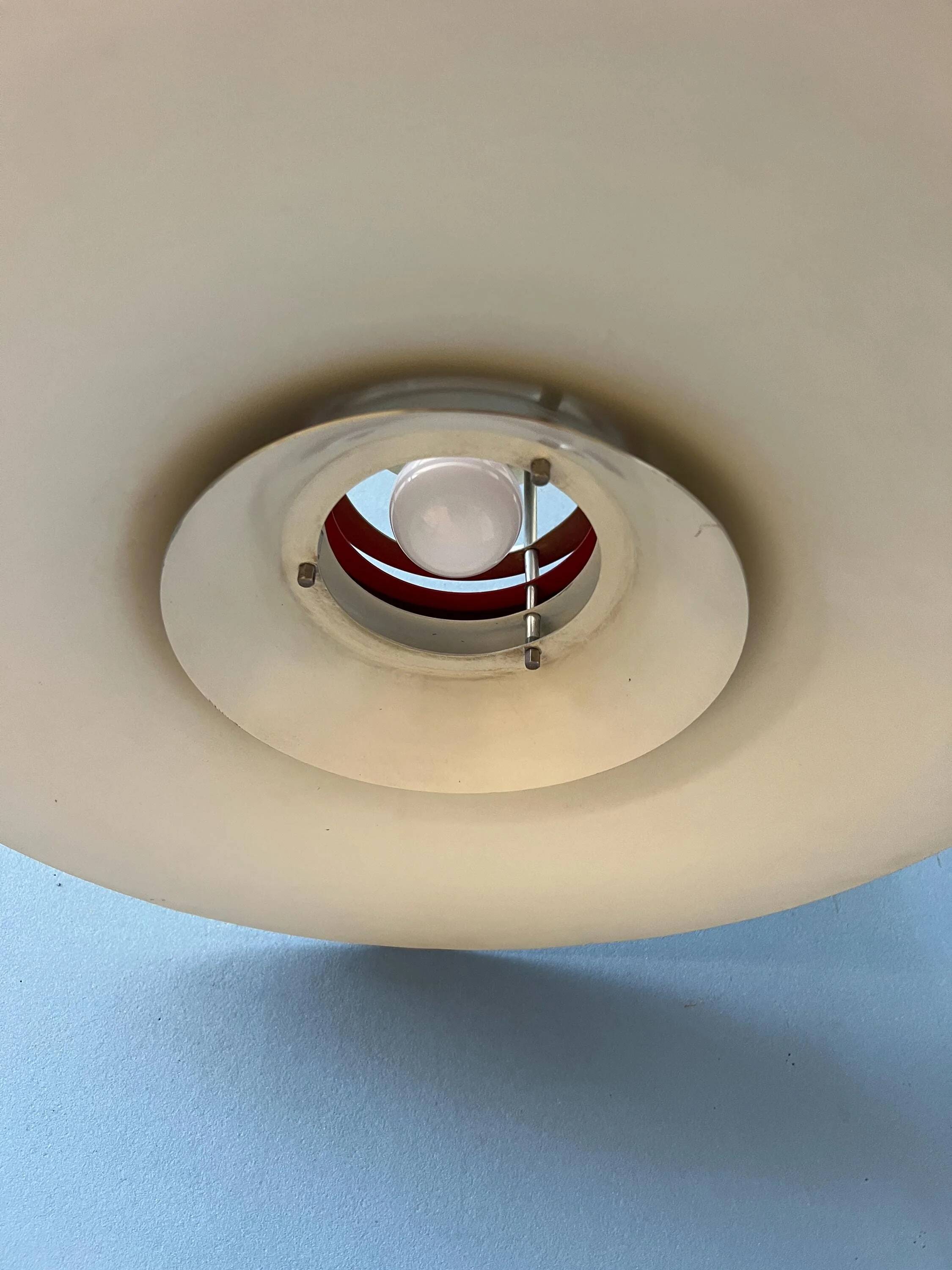 Large UFO flying saucer pendant light with orange light.