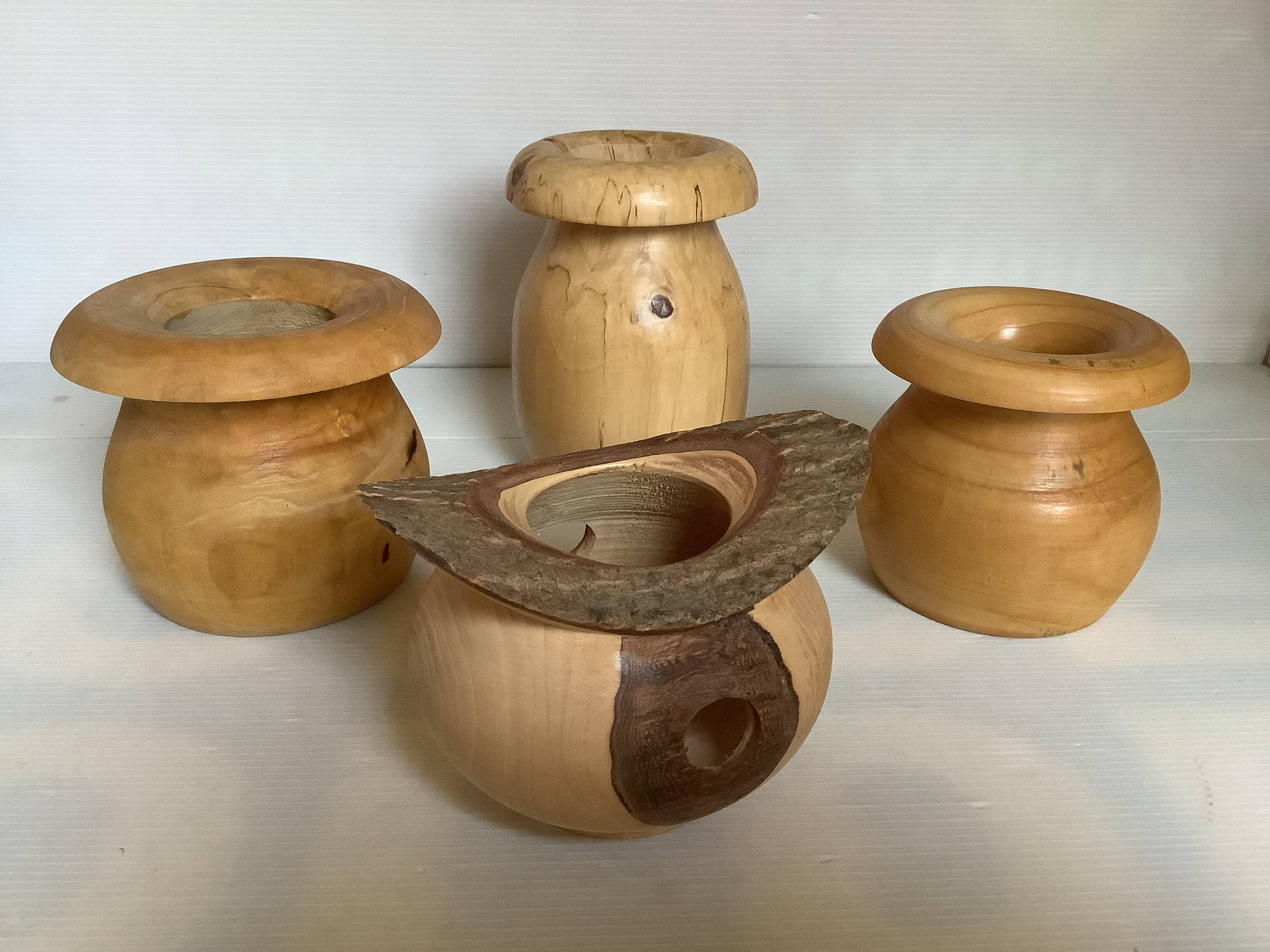 Four solid turned wooden vases