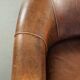 Fauteuil club en cuir de peau de mouton avec un coussin de siège fixe.