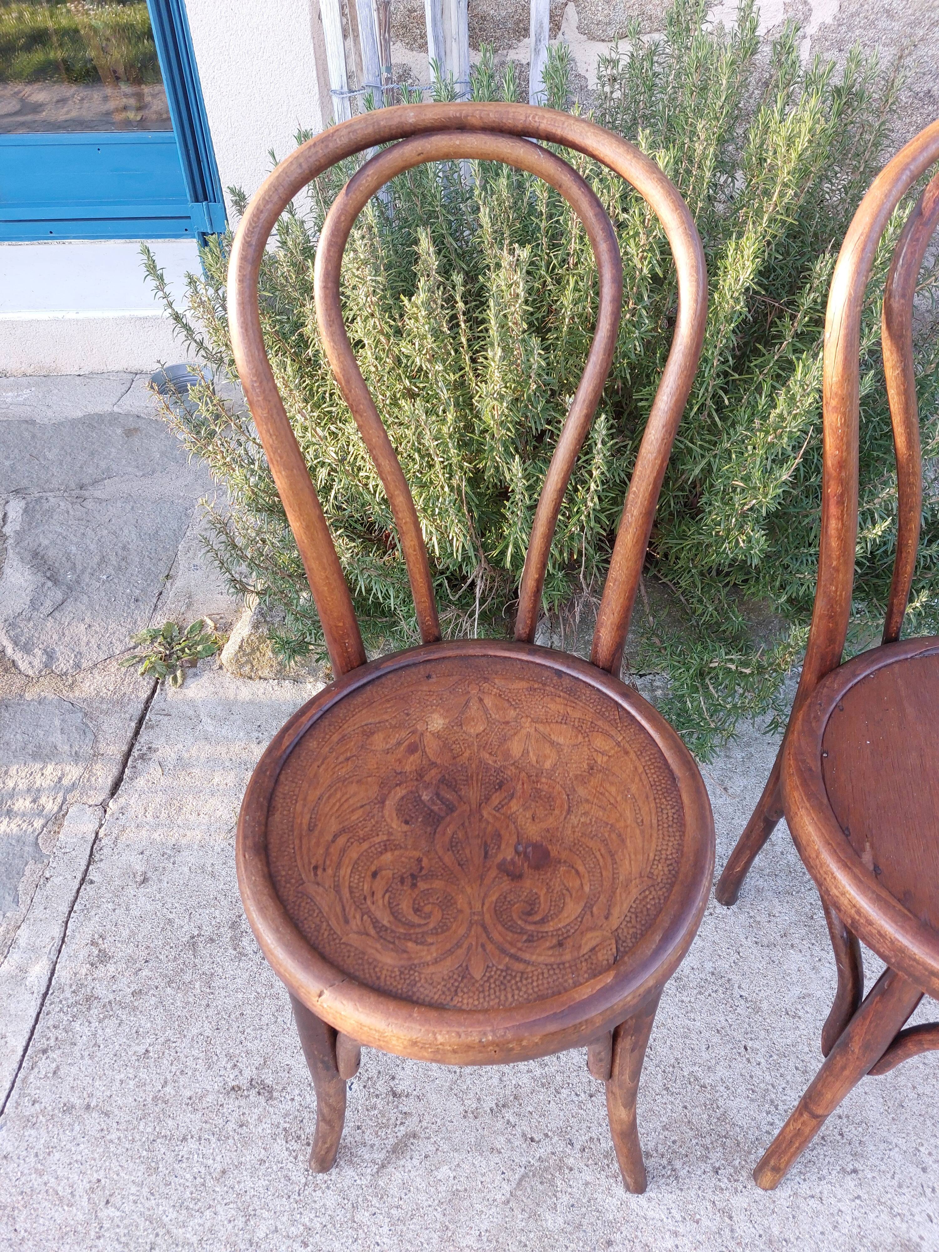pair of round wooden chairs with a pattern on the seat