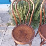 pair of round wooden chairs with a pattern on the seat