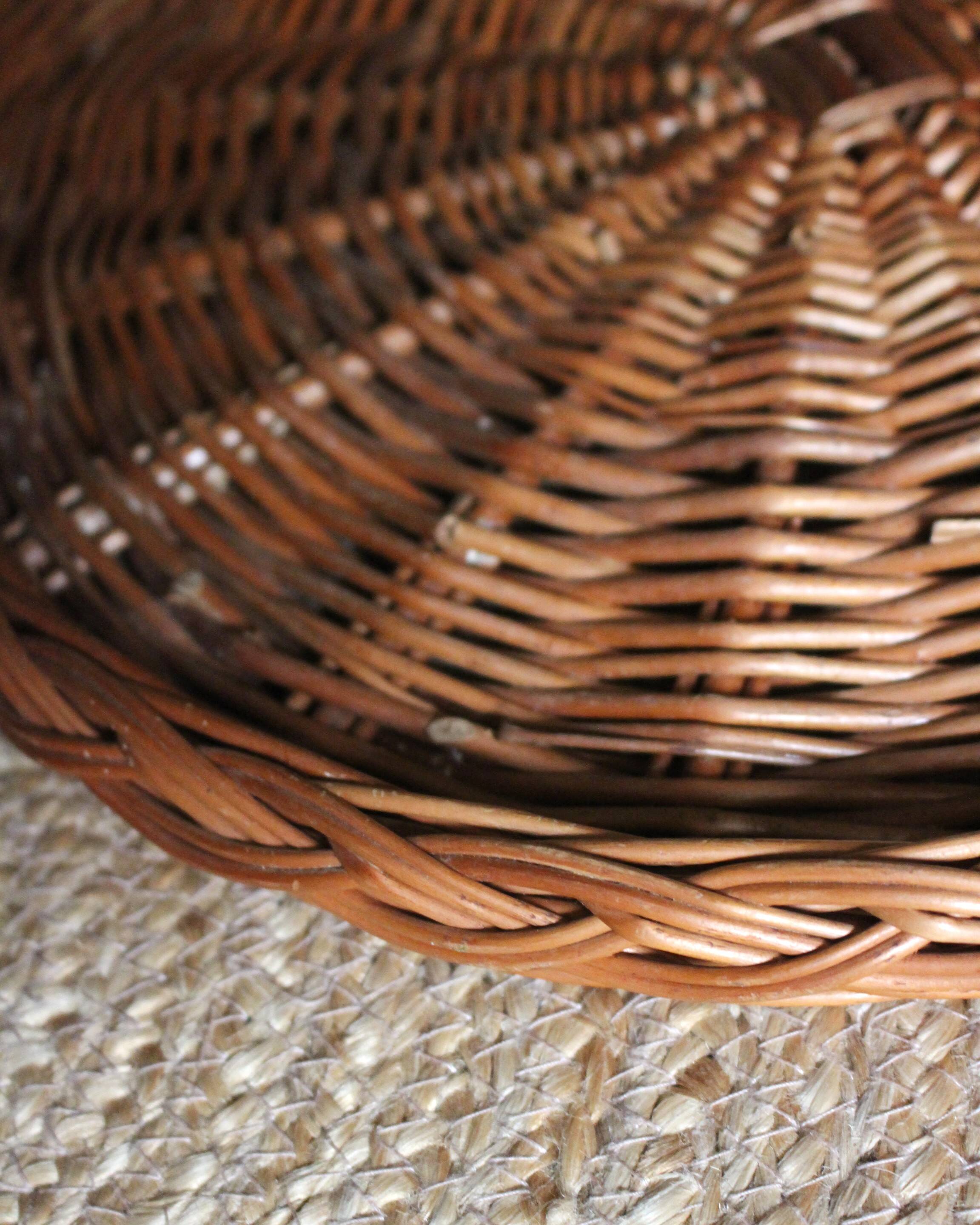 Large round dark wicker tray with two handles.