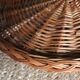 Large round dark wicker tray with two handles.