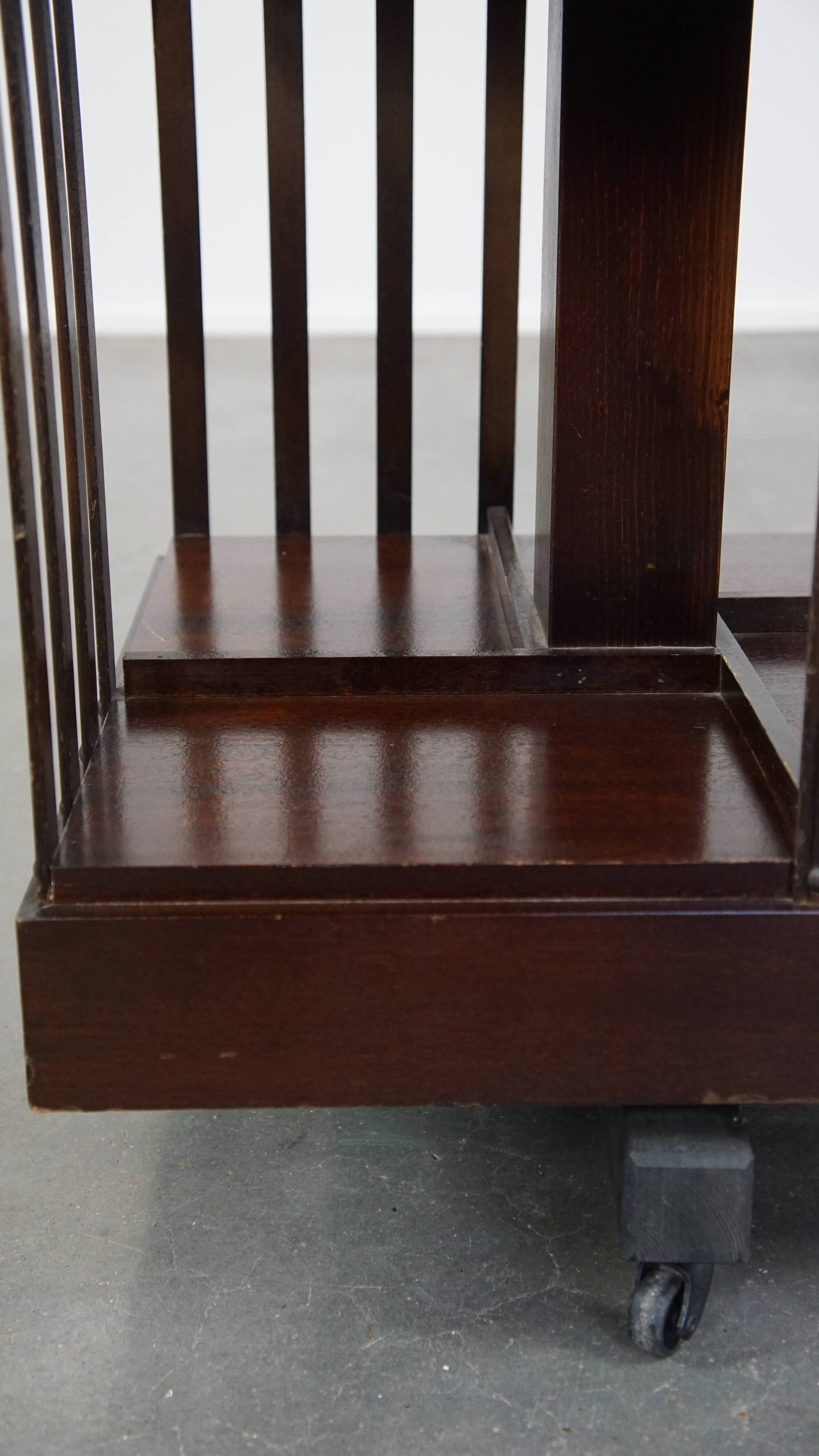Wooden bookstand with green leather surface and on wheels in English style