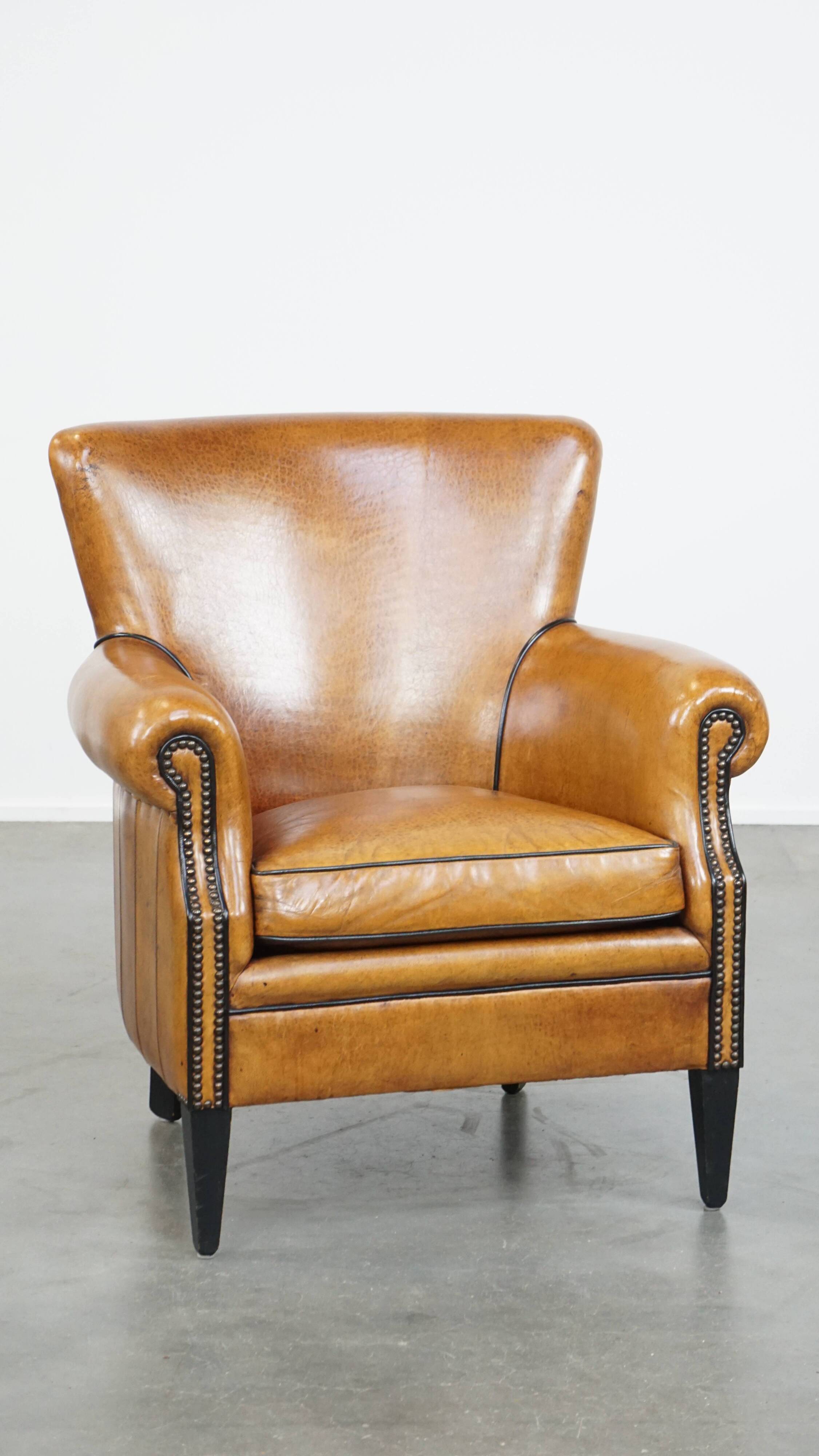 Cognac-colored sheep leather armchair finished with decorative nails