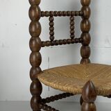 Brutalist wood turned bobbin low rush chair in the style of Charles Dudouyt
