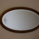 Beveled oval mirror in gilded wood