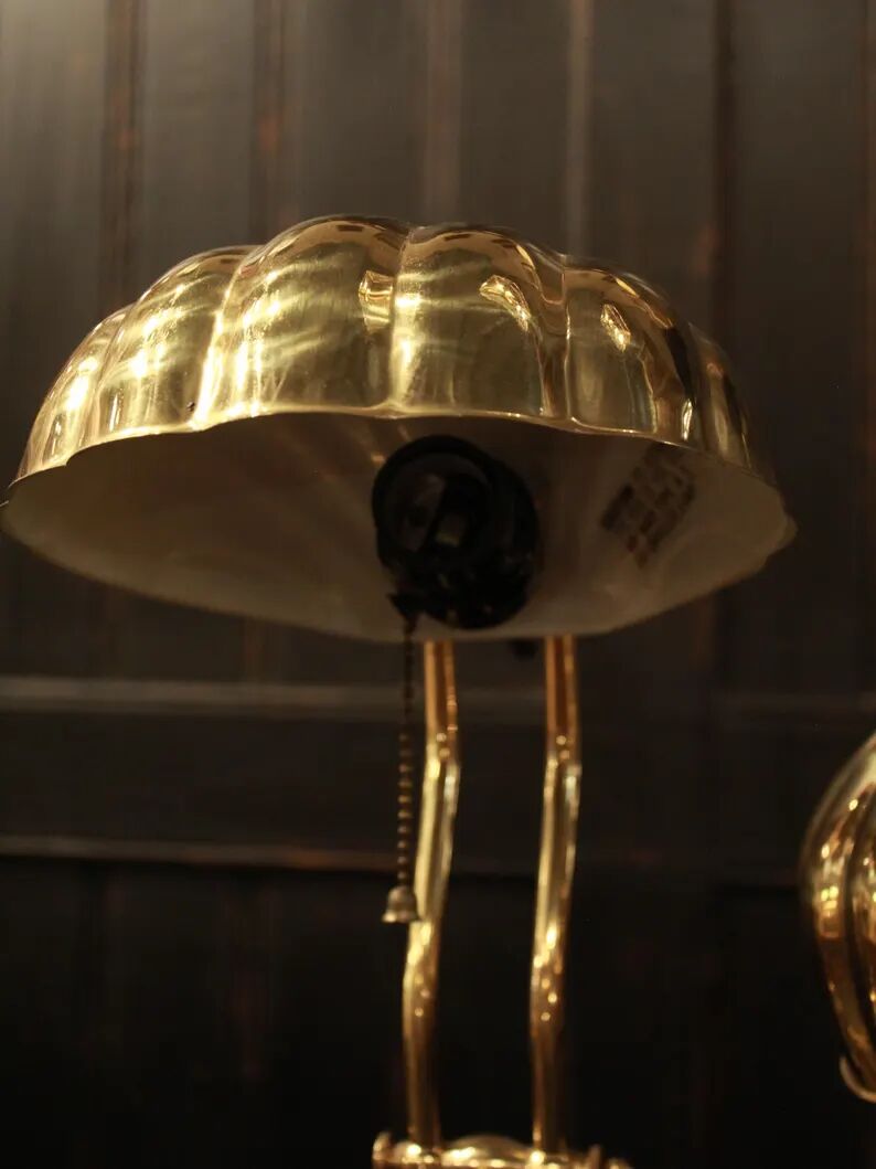 Pair of articulated brass lamps in the shape of a shell.
