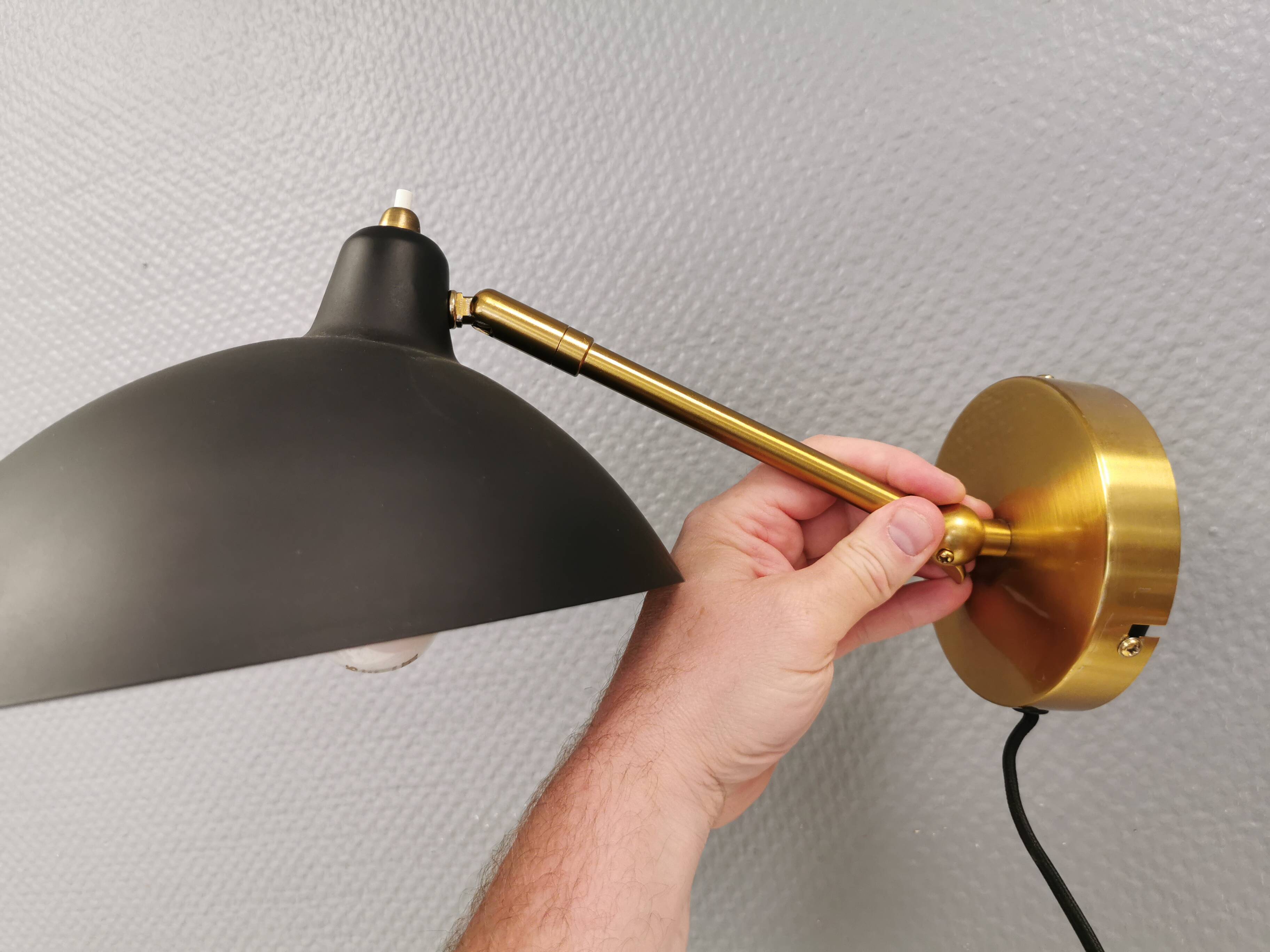 A wall lamp in black and brass-coloured finishes. Danish, early 2000s.