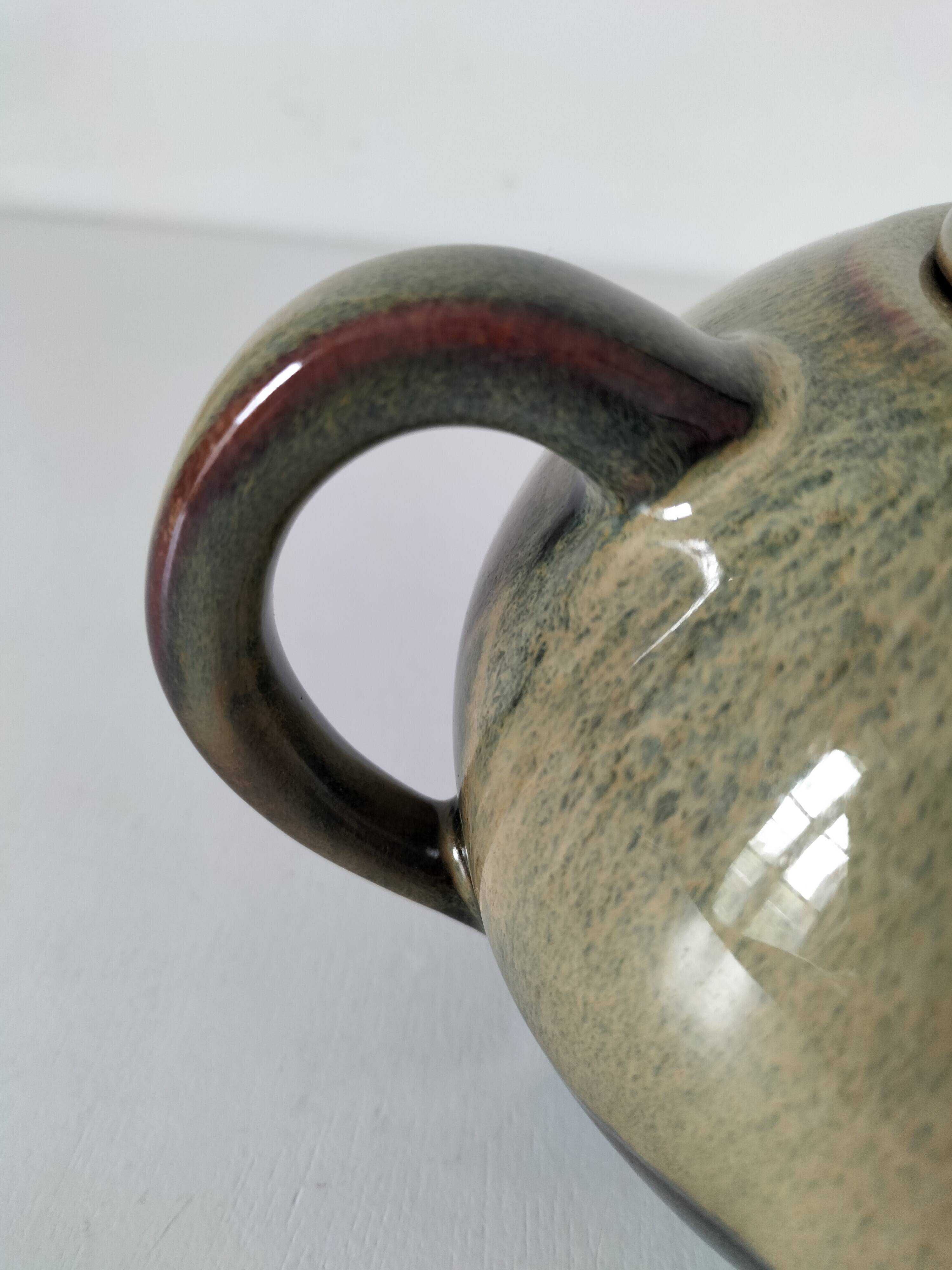 Vintage ceramic teapot with a flame design.