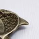 Vintage fish-shaped brass pocket emptier
