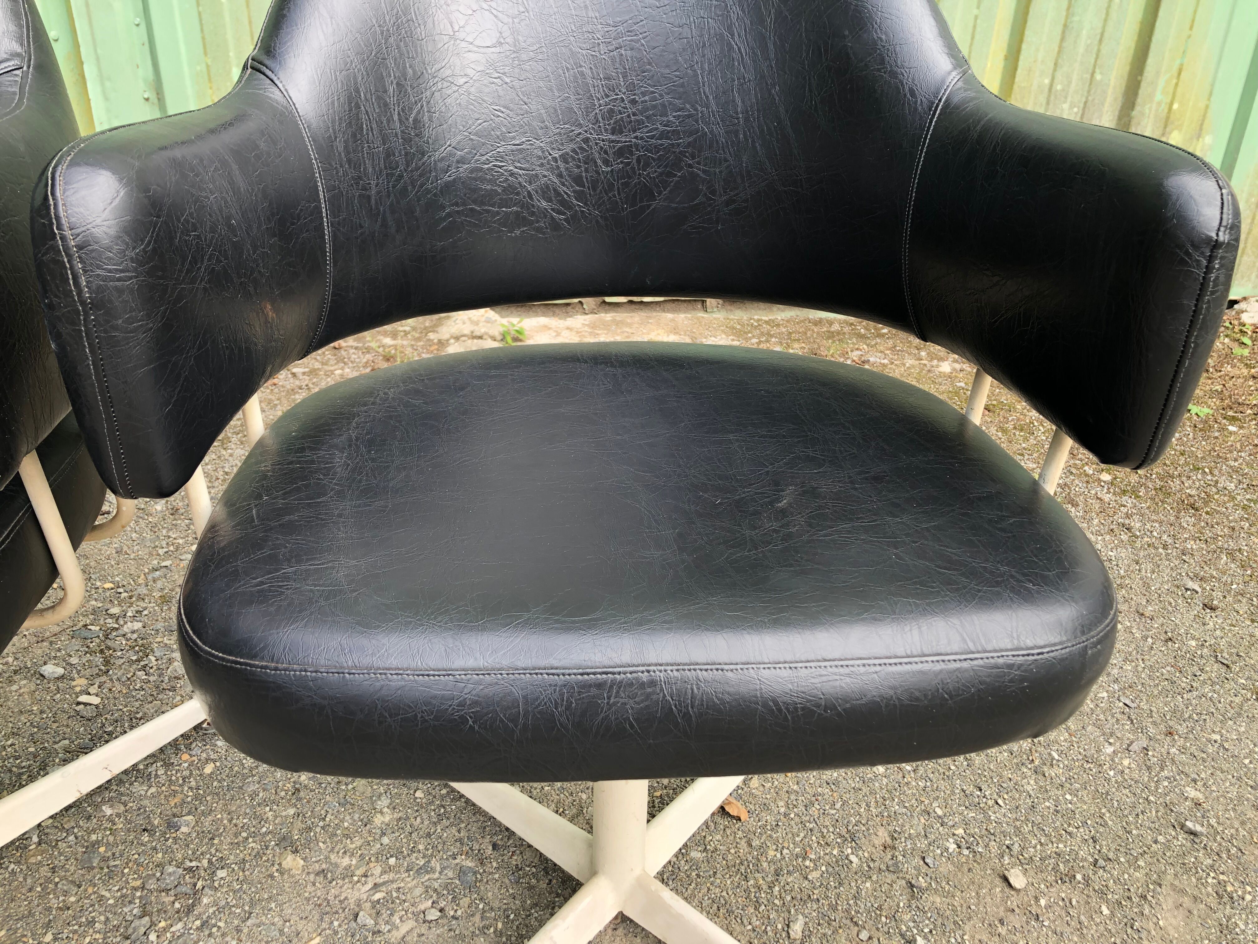 Pair of vintage armchairs in black skai with metal legs.