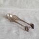 Antique silver-plated sugar tongs with lion's paws.
