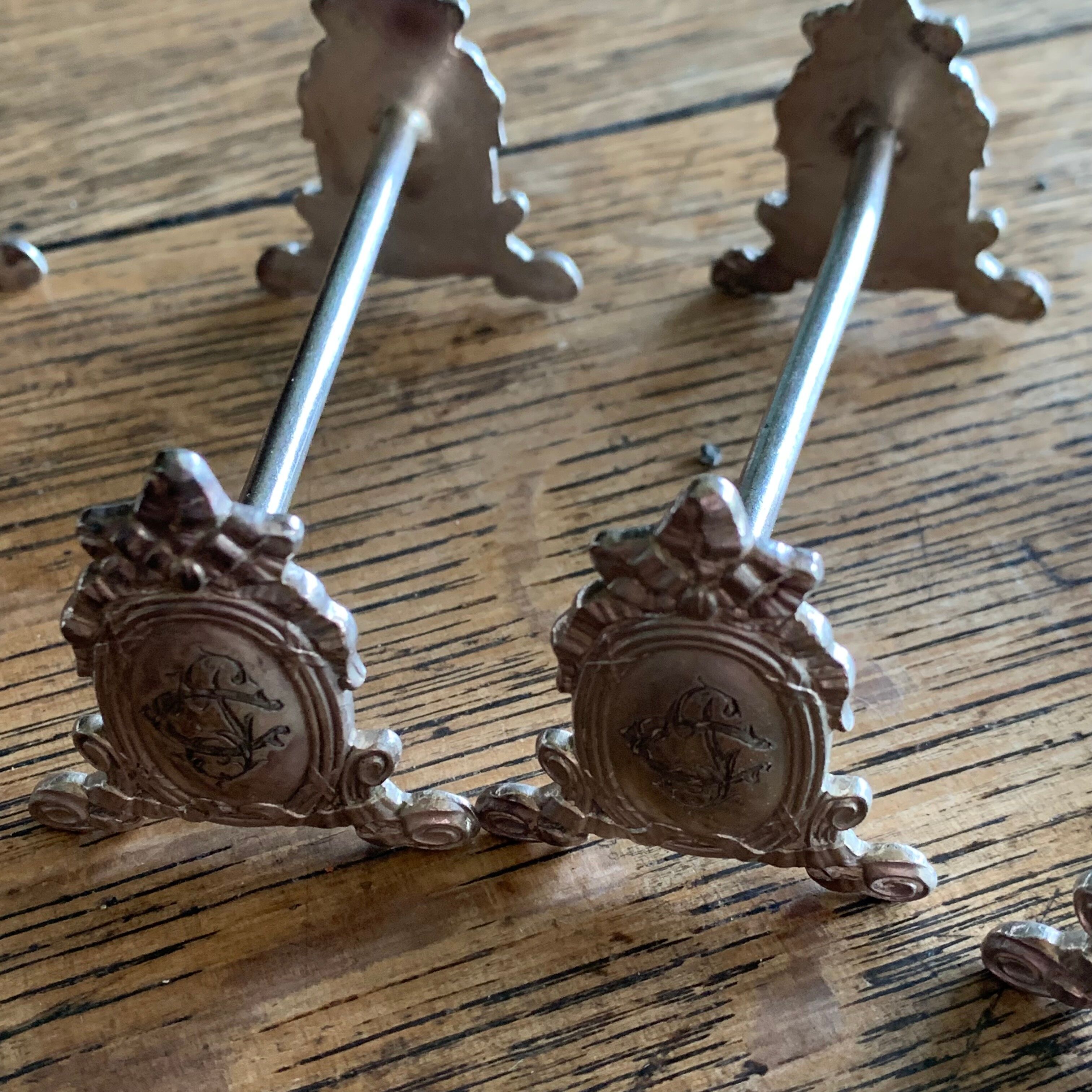 Series of 12 monogrammed silver metal knife holders