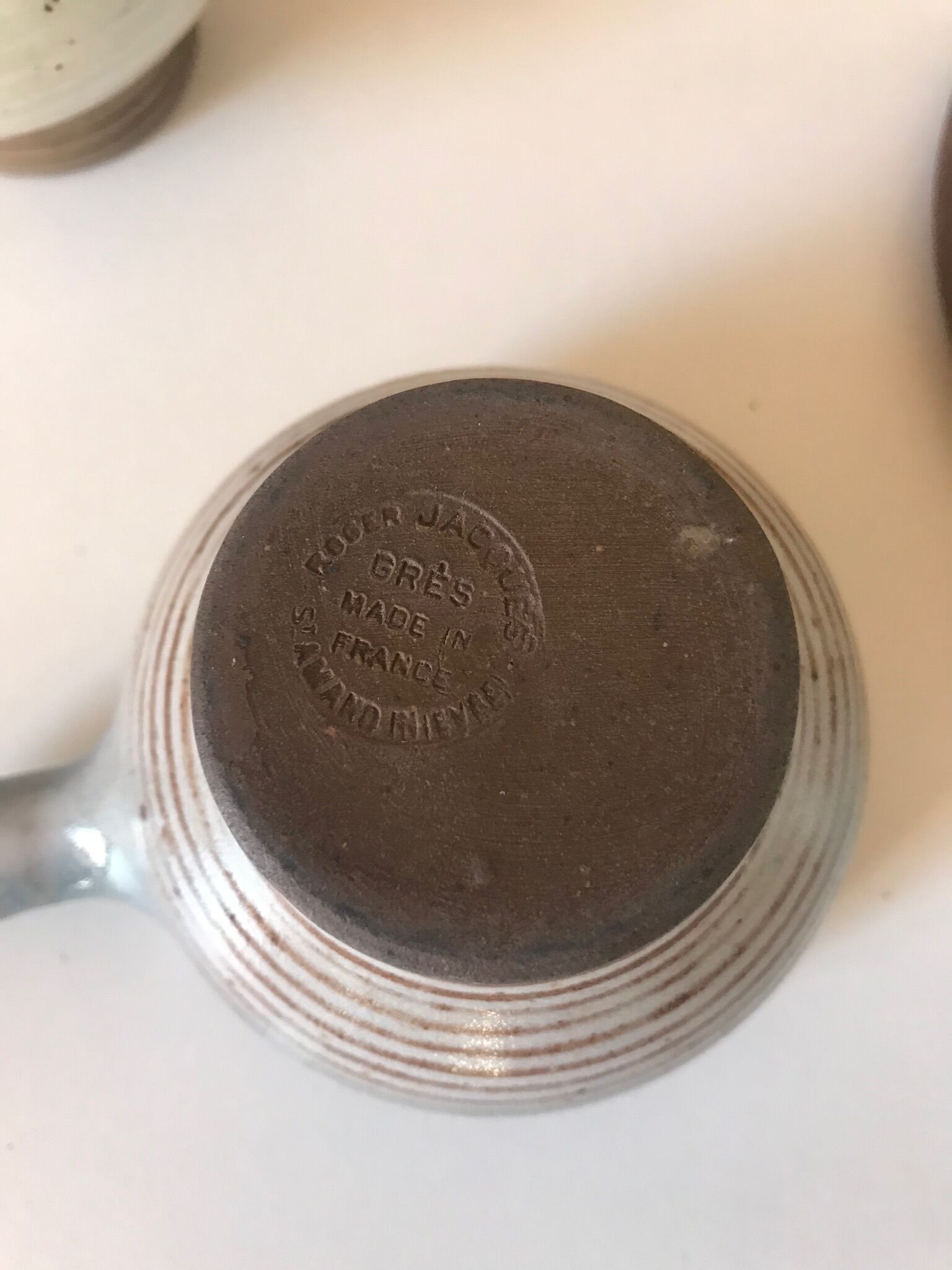 Lot 7 cups and saucers sandstone by Roger Jacques