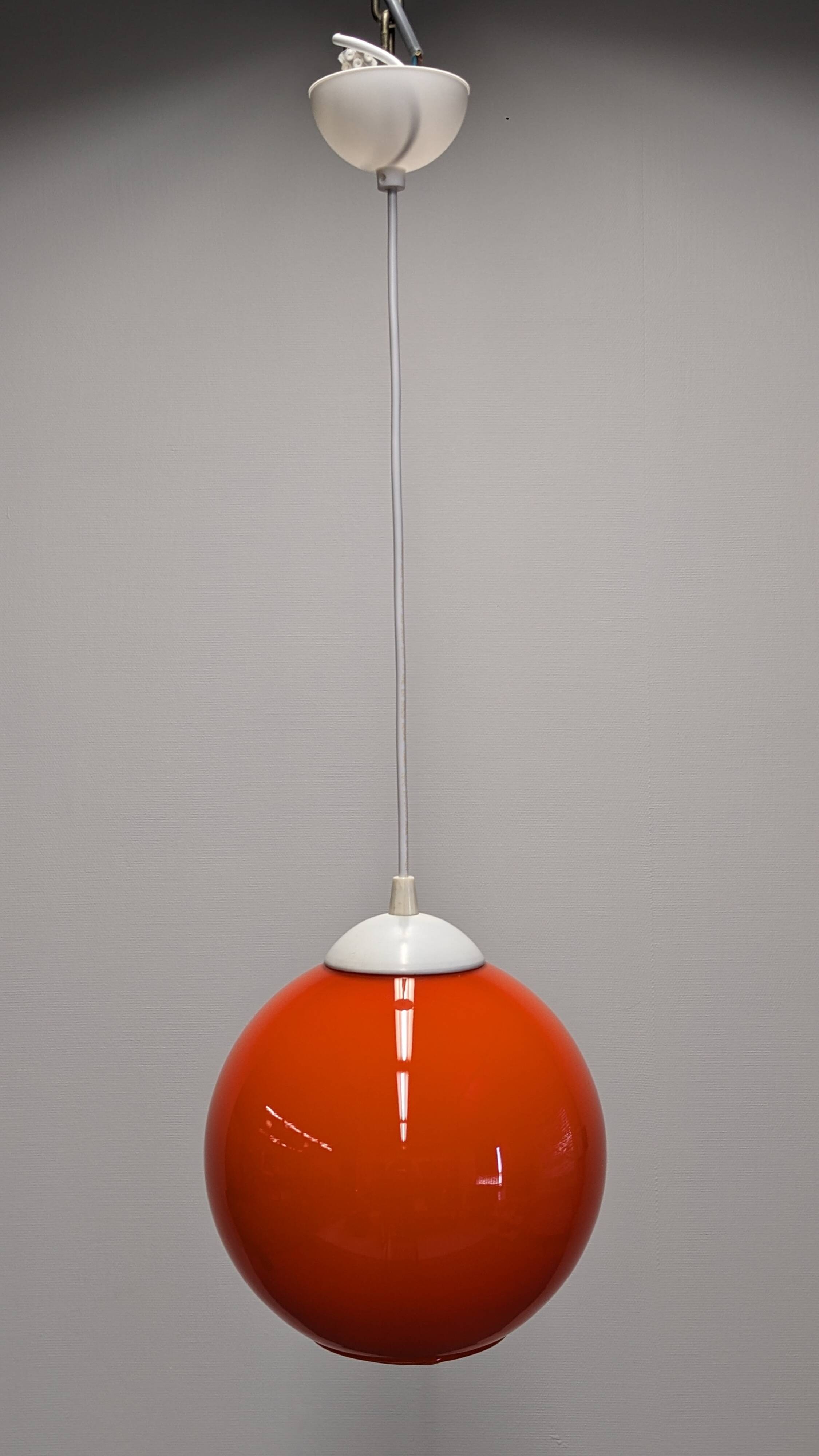Pair of spherical pendant lights in orange opaline, France circa 1970.