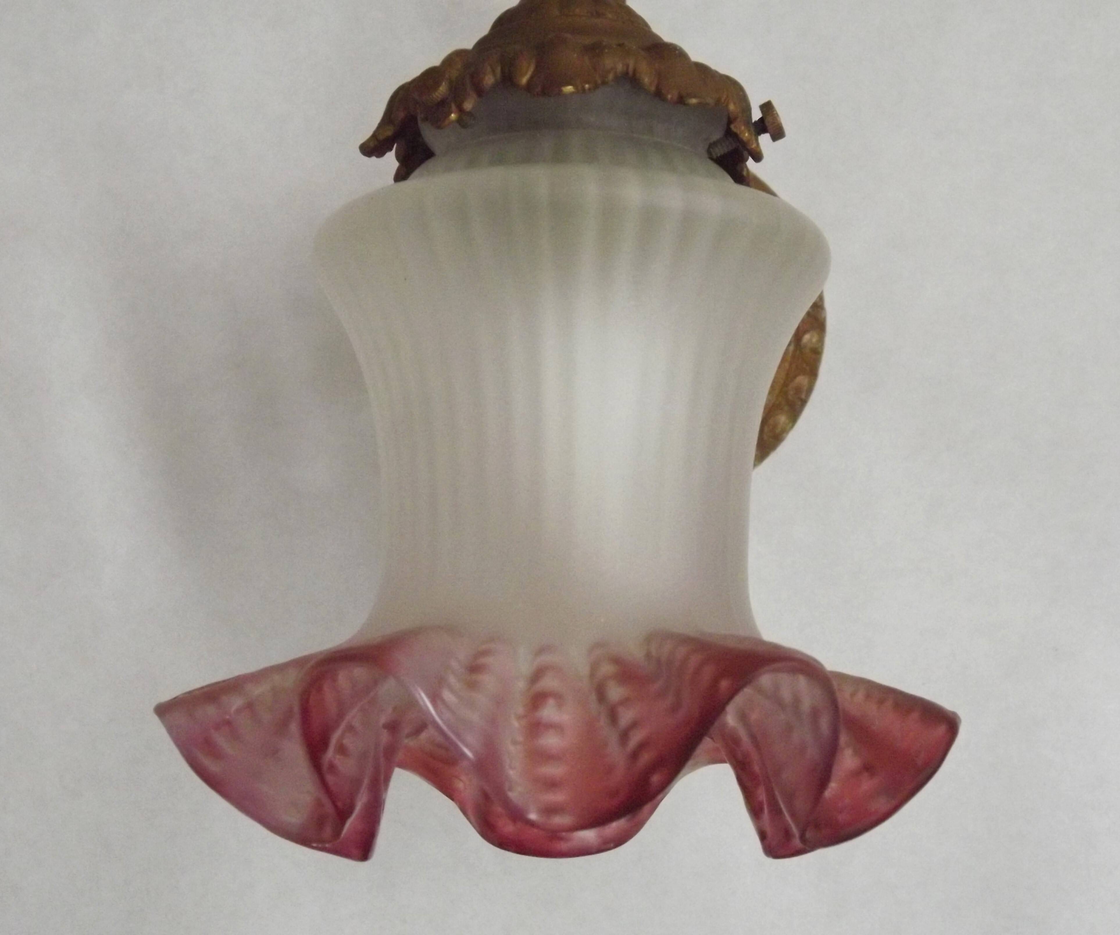 French Art Nouveau wall sconce in bronze with a white and pink glass shade.