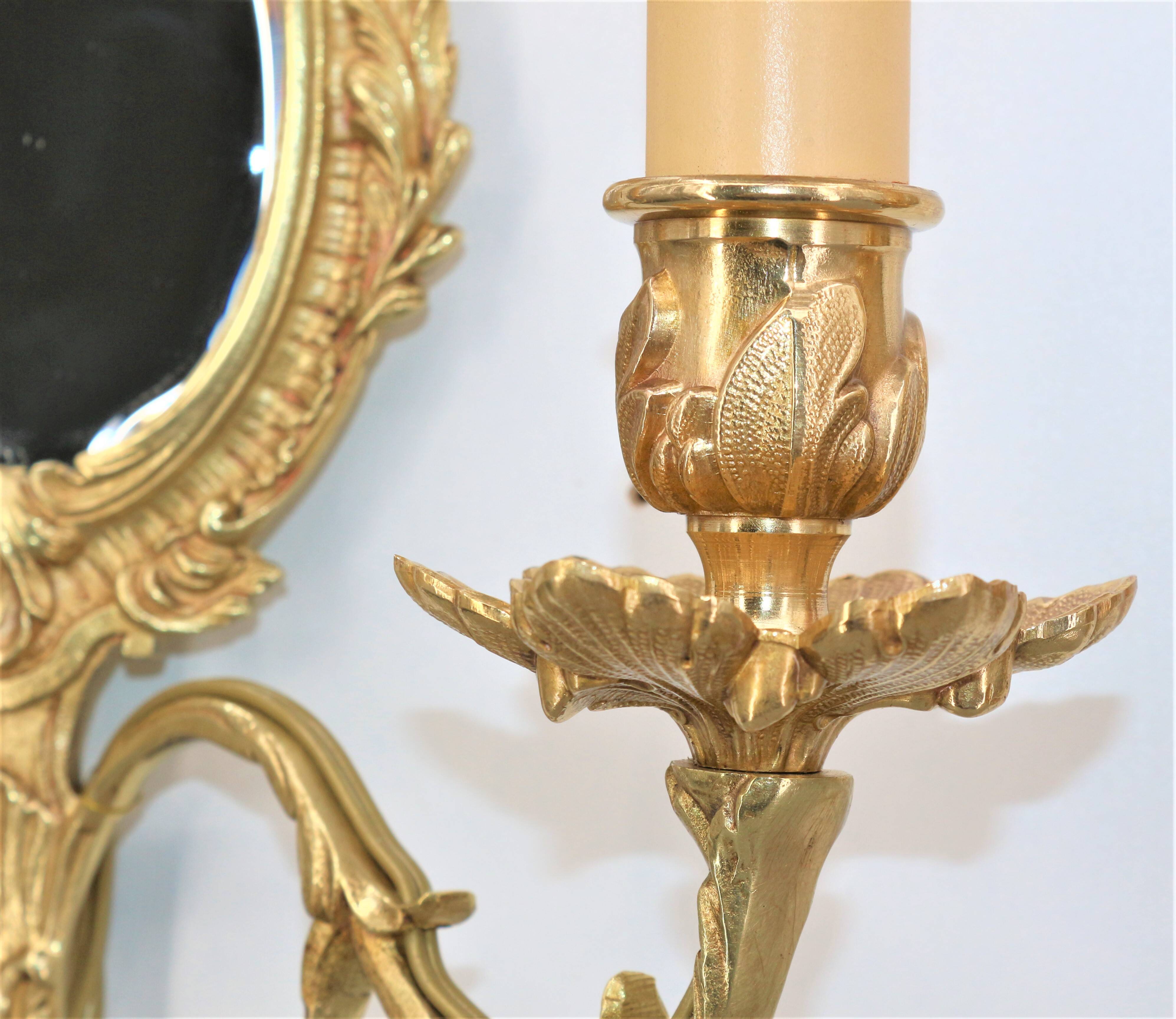 Pair of Louis XV style beveled mirror sconces in bronze by Lucien Gau