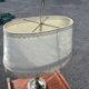 Two-armed hot water bottle lamp in silver metal with fringed fabric shade