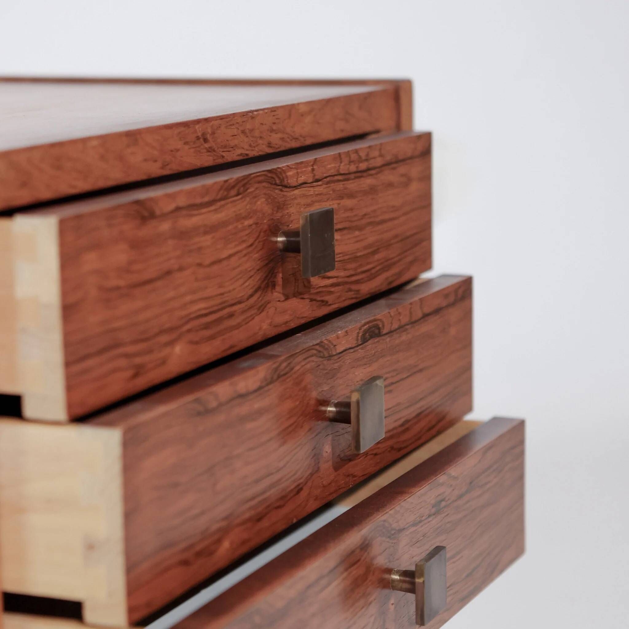 Pair of vintage Scandinavian bedside tables, three drawers, honey-toned wood.