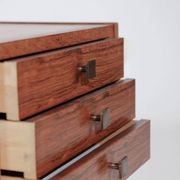 Pair of vintage Scandinavian bedside tables, three drawers, honey-toned wood.