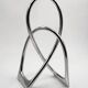 Chromed sculptural art object, abstract modernist shape in metal, contemporary design accent, brutalist interior decoration.