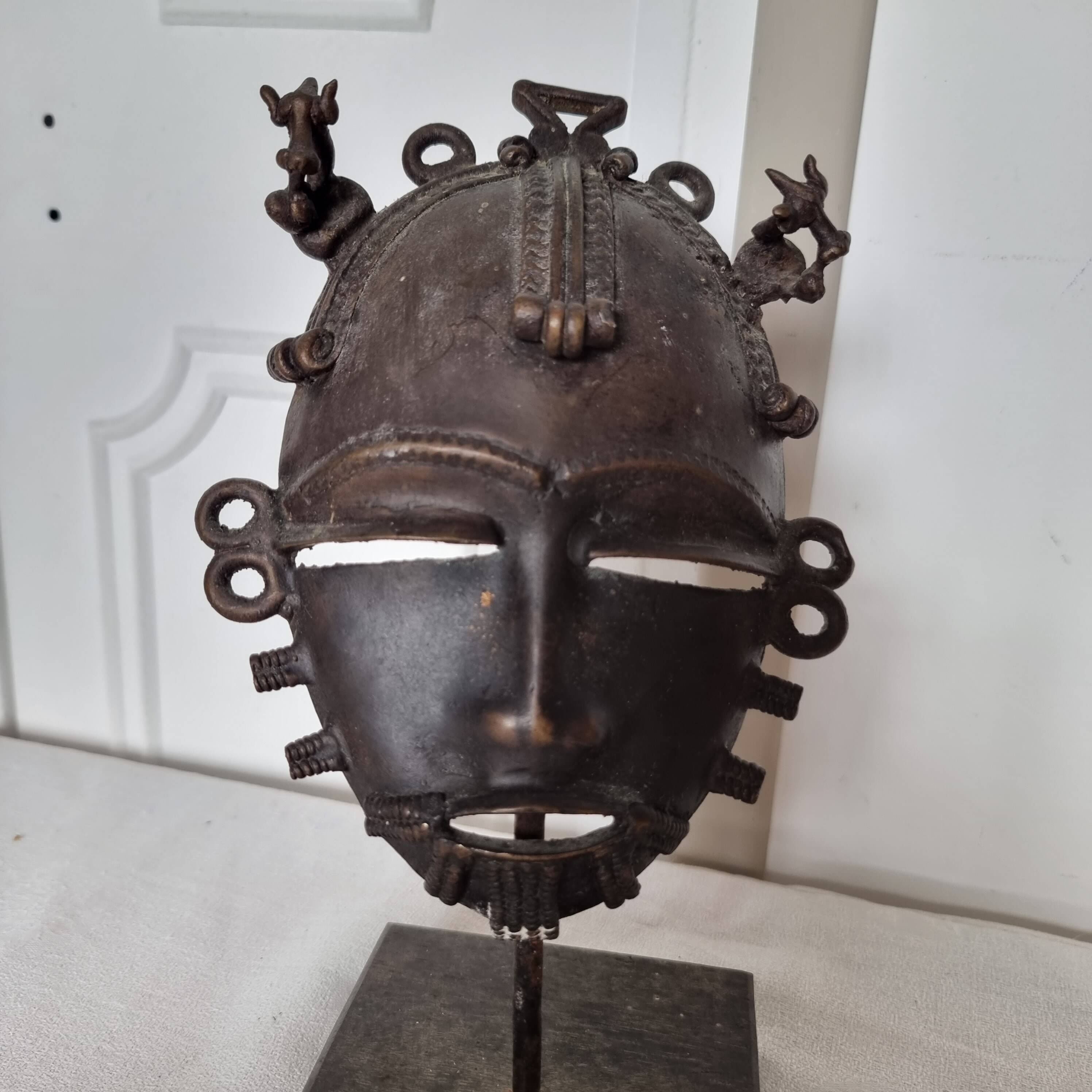 African bronze mask on pedestal, from Ivory Coast, dating