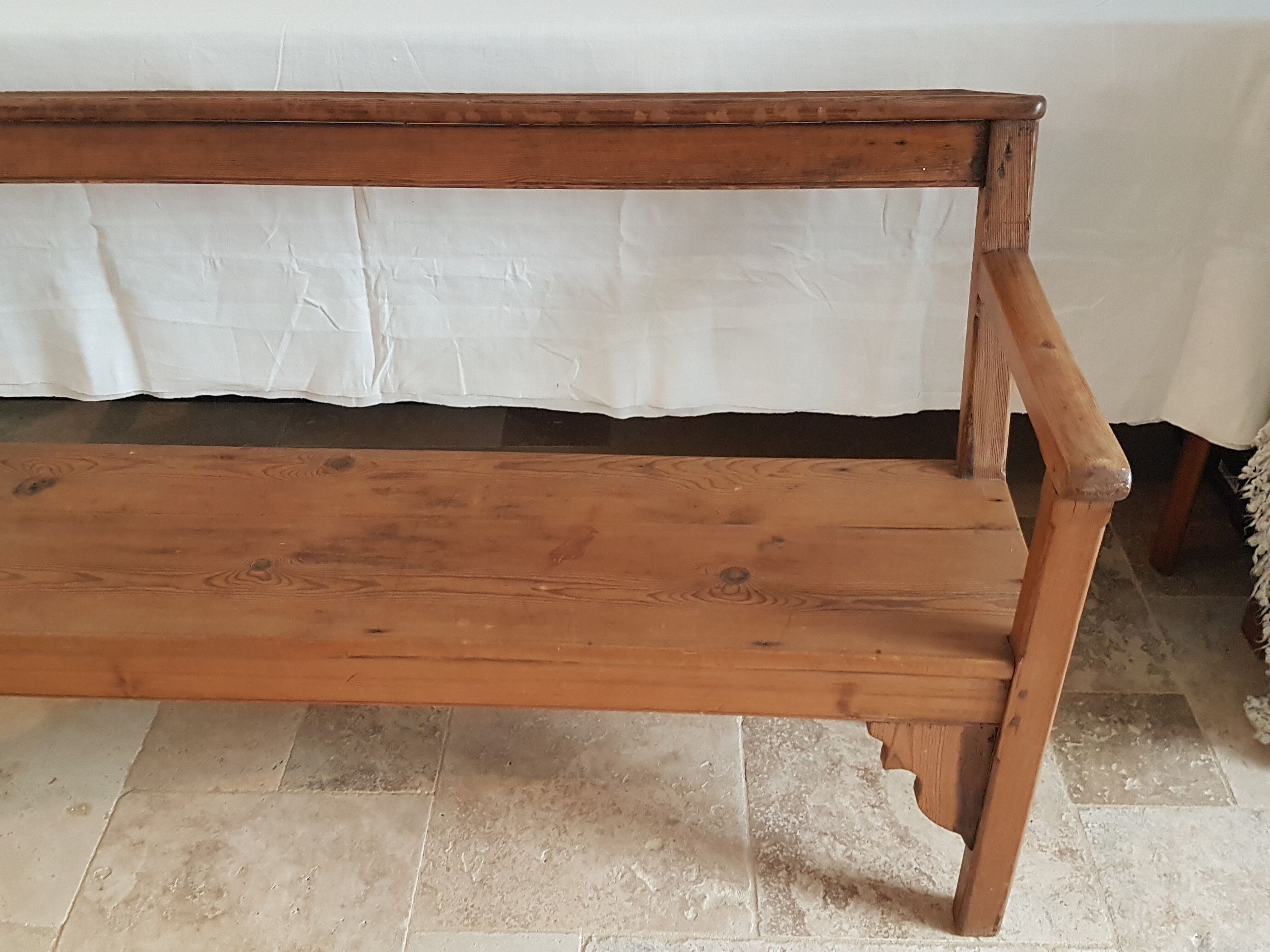 Church bench in fir tree with armrests