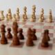 Vintage 1980s round chess set in marble, with a beige and pink marble board and wooden pieces.