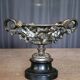 Patinated bronze cup, richly decorated with foliage and bunches of grapes