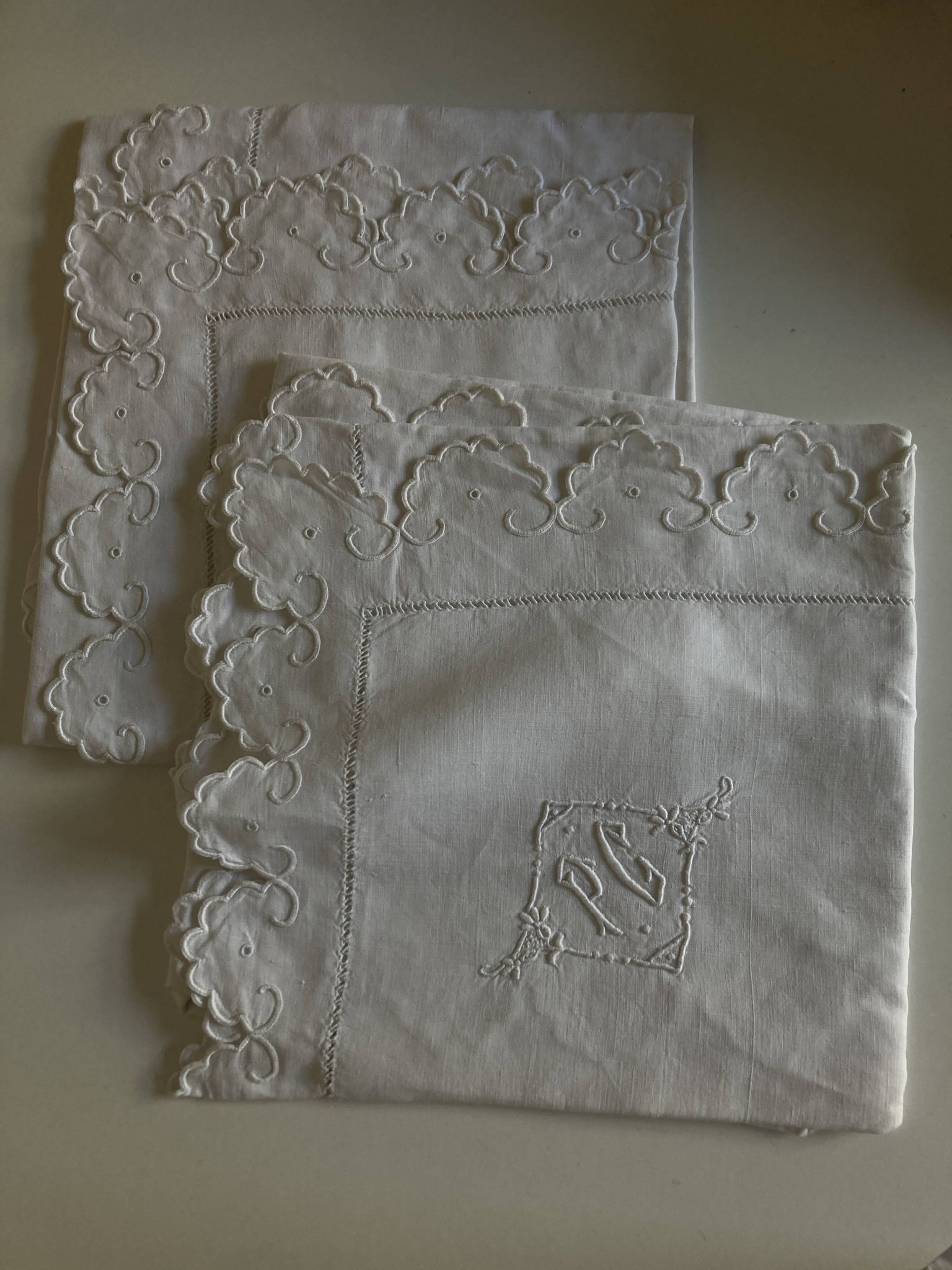 Pair of 19th-century linen pillowcases embroidered with scallops.