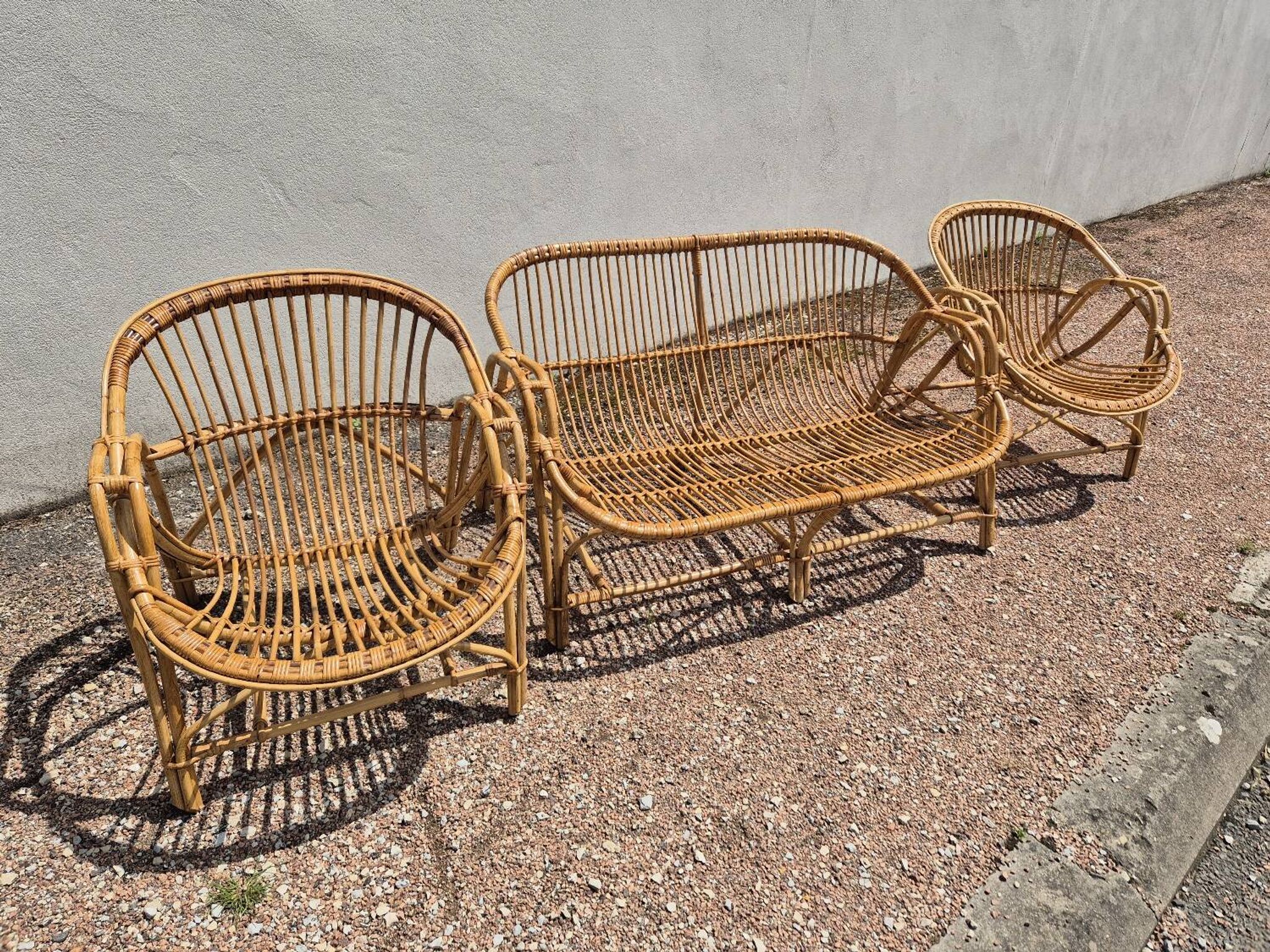Rattan lounge with two armchairs and a vintage 1950s bench.