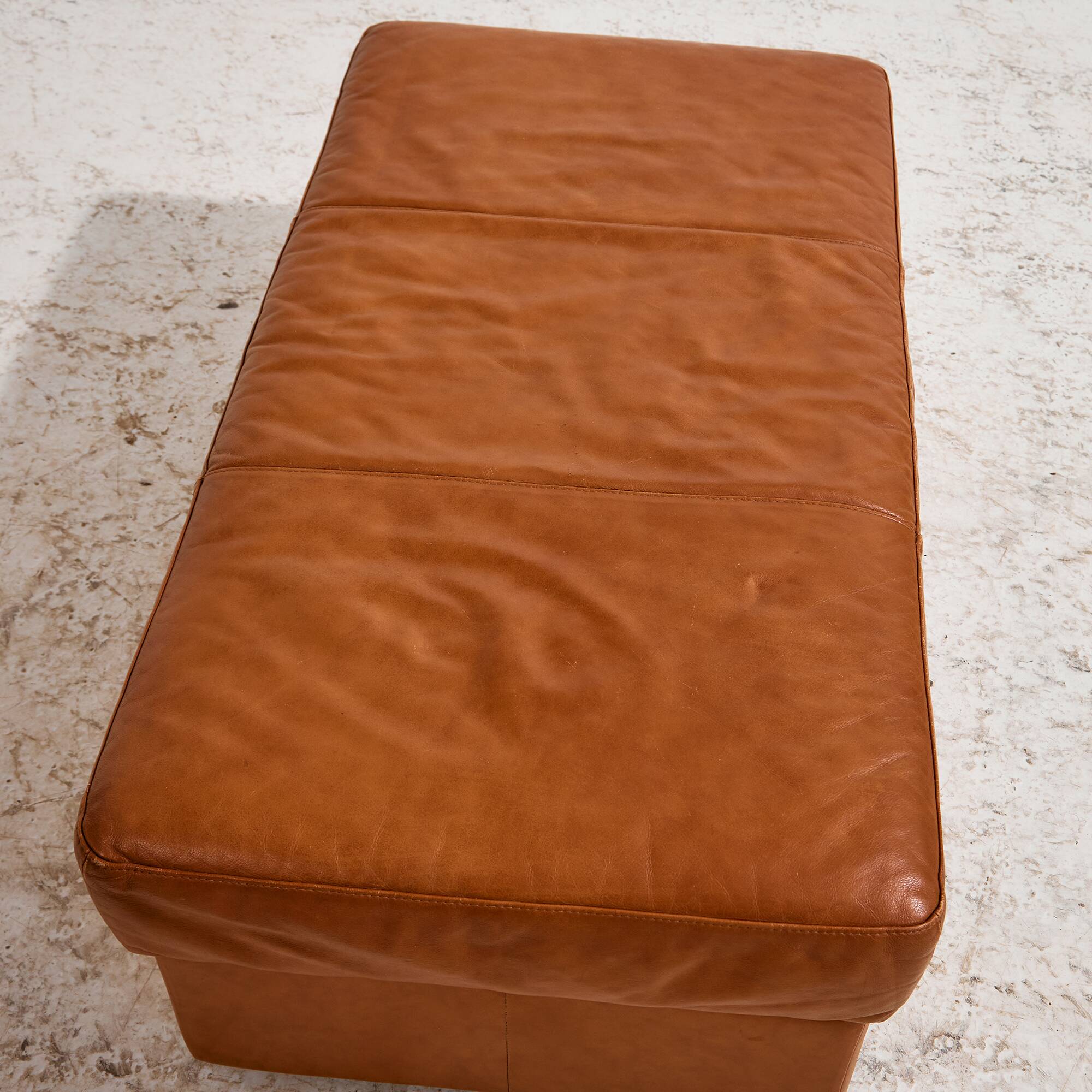 Ottoman with leather upholstery