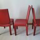 Red leather dining chairs by Arper