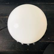 Black wrought iron lamp with a white glass globe.