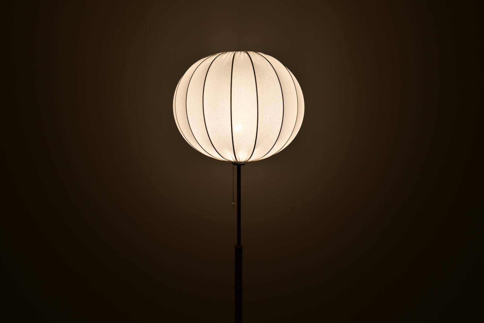 Mid-century floor lamp in brass and oak by Falkenbergs Belysning, Sweden, 1960s.