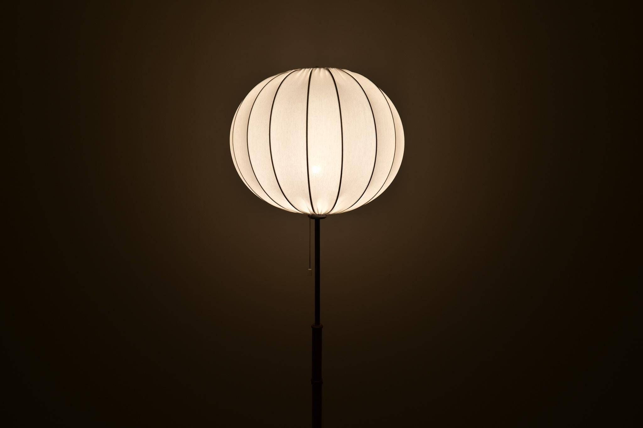 Mid-century floor lamp in brass and oak by Falkenbergs Belysning, Sweden, 1960s.