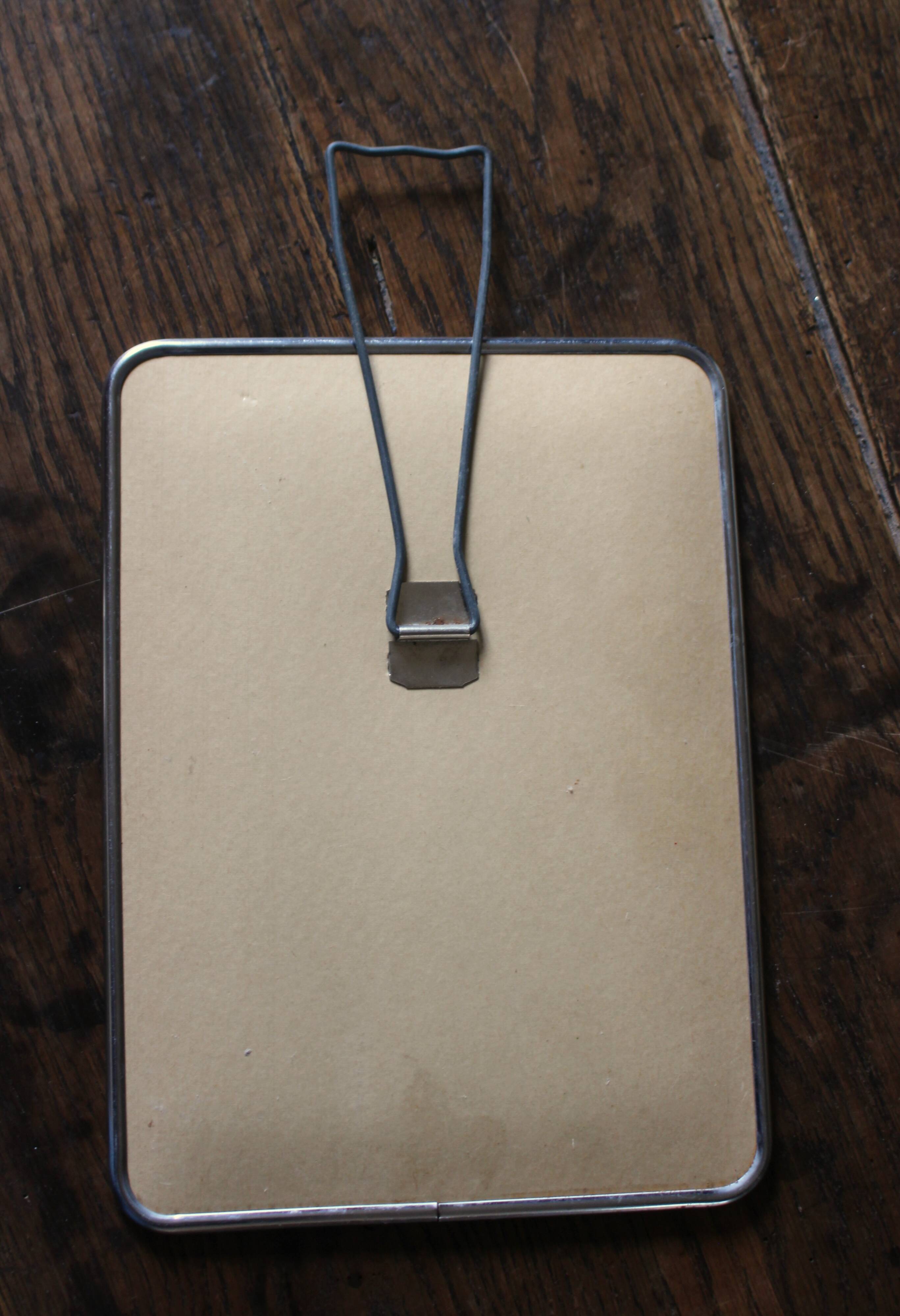 Simple rectangular barber mirror with a stand.