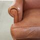 Fauteuil anglais à oreilles de couleur cognac clair en cuir de vache.