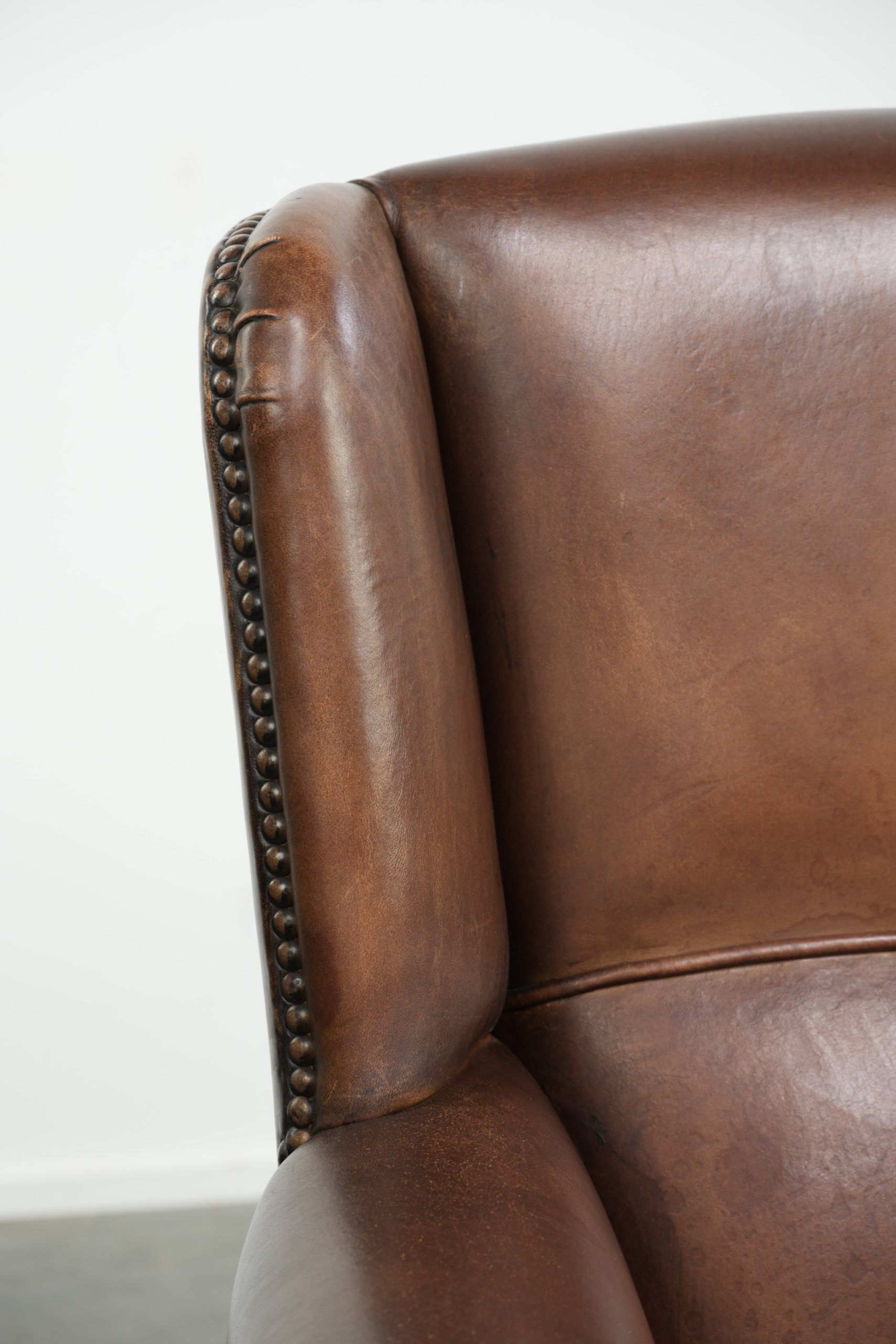 Subtle dark brown sheepskin wingback armchair with a timeless look subtle