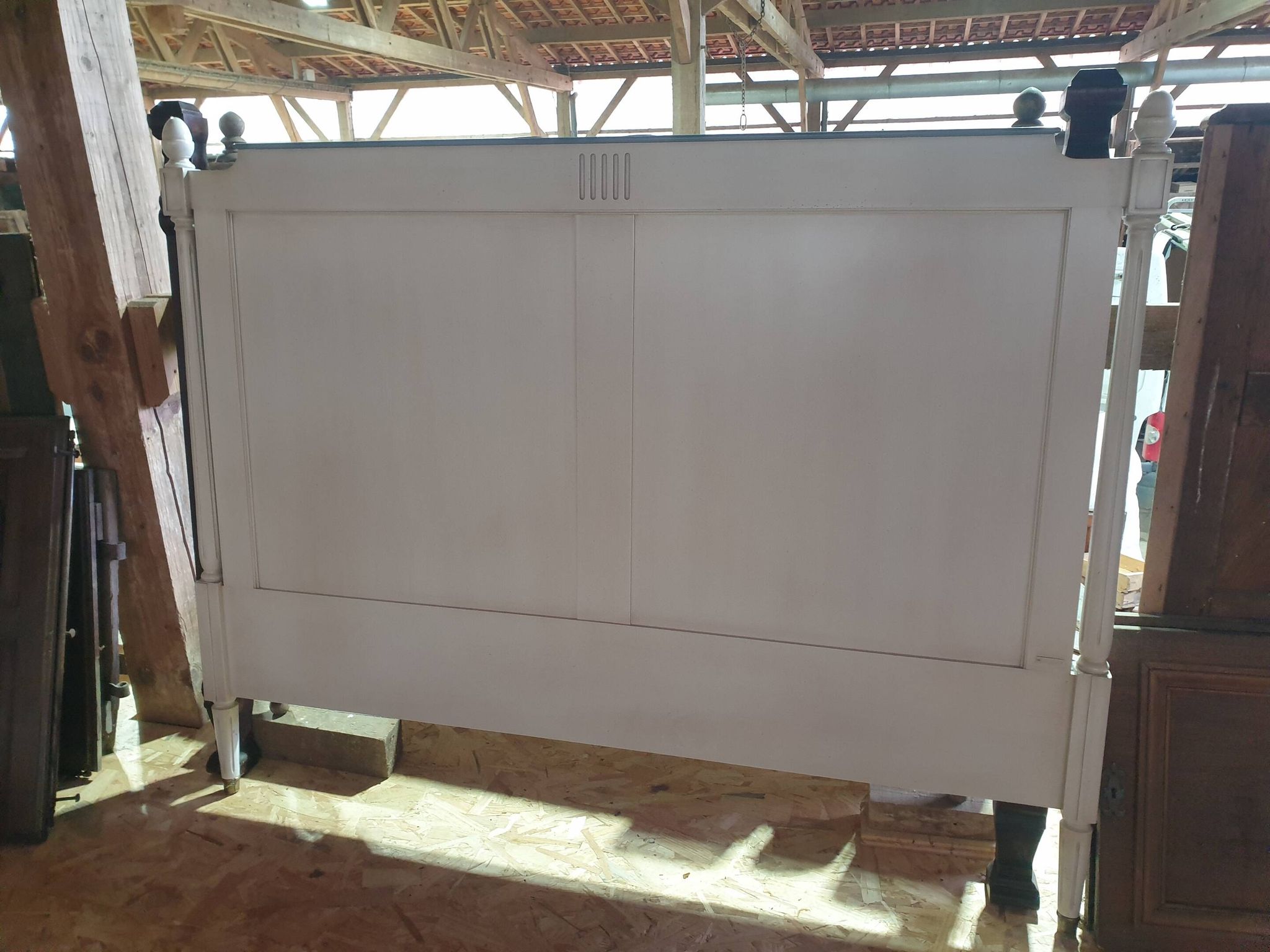 White headboard in Napoleon style with brass feet.
